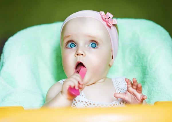 Legrační dítě s růžovými lžičkou v ústech — Stock fotografie