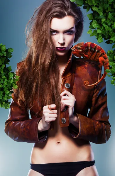 Pretty erotic devil woman in leather jacket with chameleon under — Stock Photo, Image