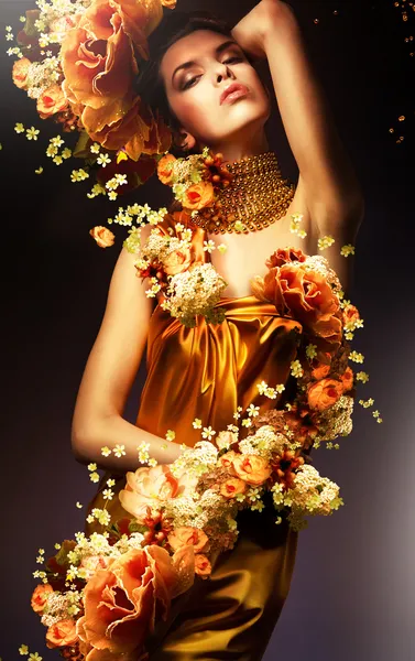 Αισθησιακή γυναίκα σε μακρά κίτρινο φόρεμα και τα λουλούδια — Φωτογραφία Αρχείου