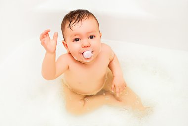 Lovely baby boy taking in bath clipart