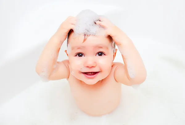 Szczęśliwe dziecko pralki w łazience w pianki — Zdjęcie stockowe