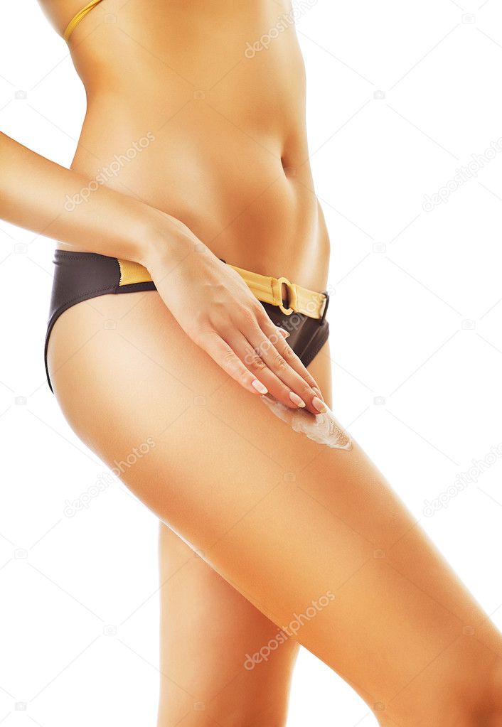Slim woman with cream on right leg