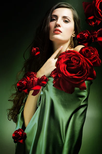 Vrouw in de groene weefsel met rode rozen — Stockfoto
