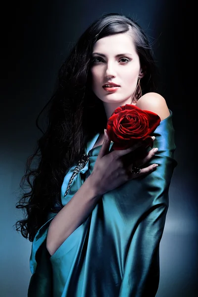 Atraktivní žena v zelené látky s růží — Stock fotografie