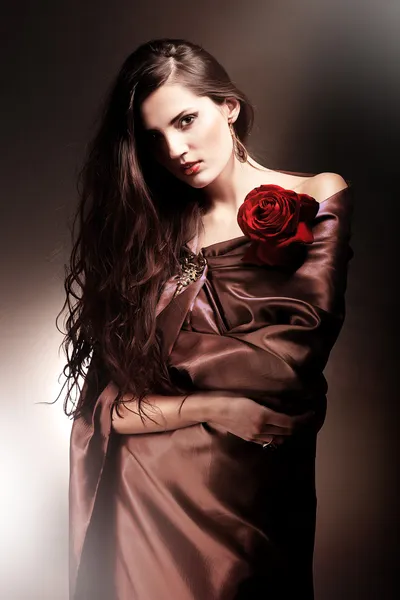 Belle femme en tissu chocolat avec rose rouge — Photo