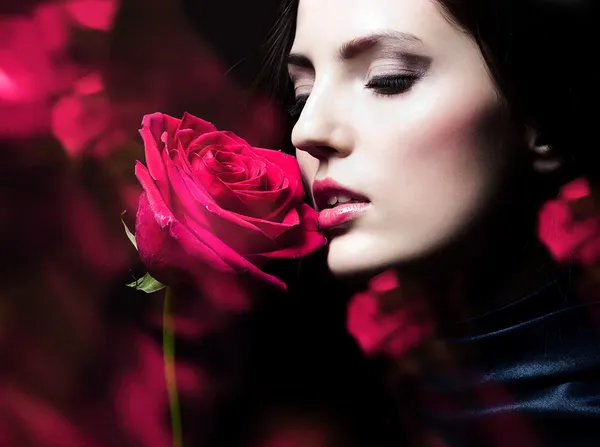 빨간 장미와 함께 아름 다운 갈색 머리 여자의 클로즈업 초상화 — 스톡 사진