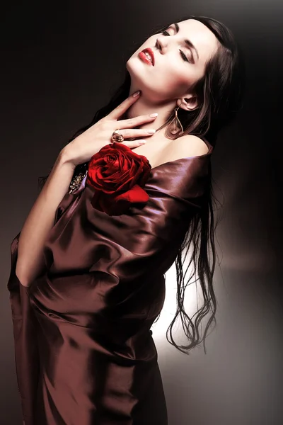Vrouw in chocolade draperie met rode roos — Stockfoto