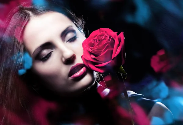 Frau mit roter Rose und blauem Licht — Stockfoto