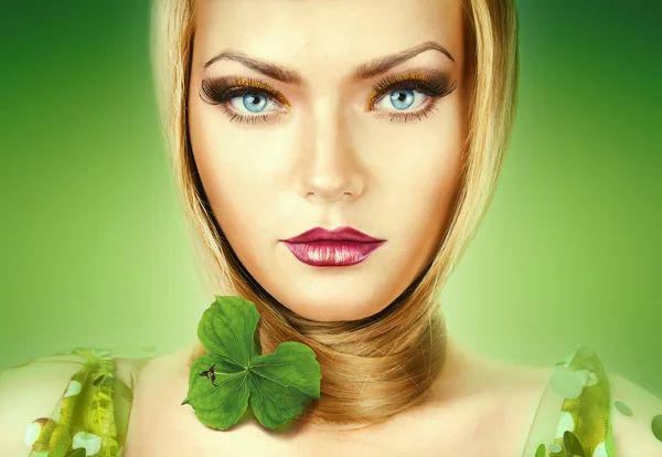 在绿色背景上的蓝眼睛的金发女人 — 图库照片