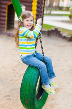 Happy childhood - portrait of swinging girl clipart