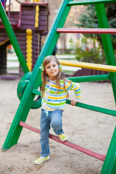 Uma linda jovem garota se divertindo no playgroung — Fotografia de Stock