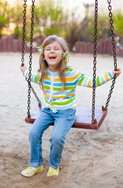Glückliche Kindheit - Porträt eines schaukelnden Mädchens — Stockfoto