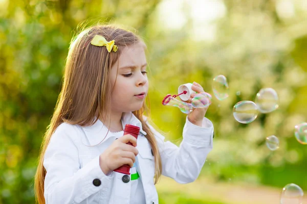 Cute Little girl blowing soap bubbles — Stock Photo, Image