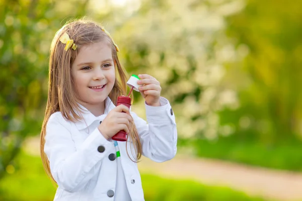 Cute fashionable Little girl blowing soap bubbles — Stock Photo, Image