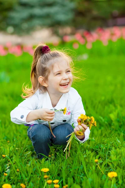Cute little girl with dandelions — Stock Photo, Image
