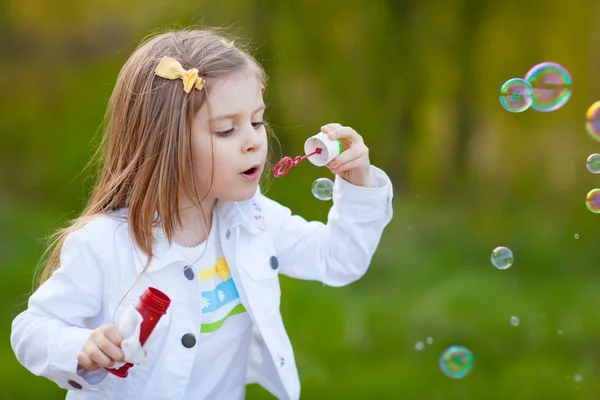 Klein meisje blazen zeepbellen Stockfoto