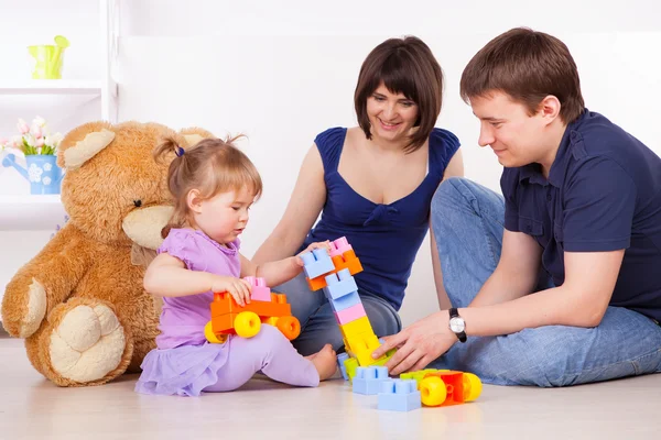 Gelukkige ouders spelen met kind thuis Stockfoto