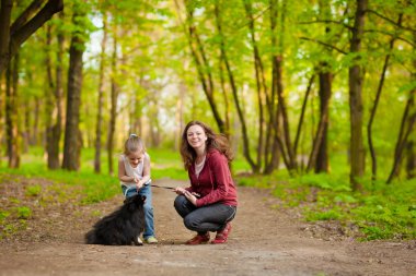 Anne ve çocuk köpekle oynamayı yürüyüş