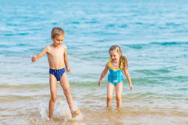 Happy kids playing at the beach shore