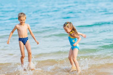 Happy kids playing at the beach shore