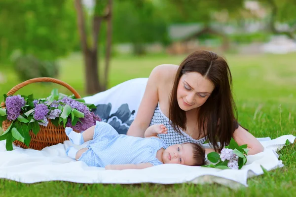 Mãe feliz e bebê descansando no parque de verão — Fotografia de Stock