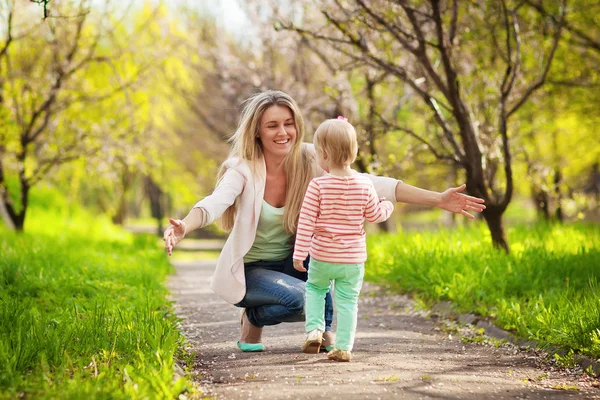 봄 정원을 걷고 있는 어머니와 딸 스톡 사진