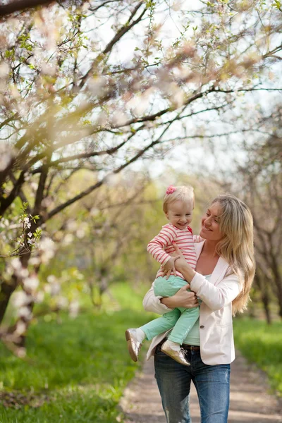 봄 정원을 걷고 있는 어머니와 딸 스톡 이미지