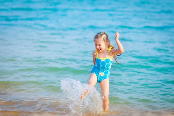 Gelukkig meisje in de zee. plezier met waterdruppels Stockfoto