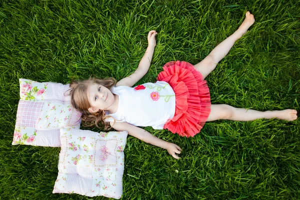 Маленька дівчинка спить на подушках в літньому саду — стокове фото