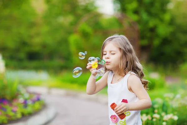 Roztomilá kudrnatá dívka s mýdlové bubliny — Stock fotografie