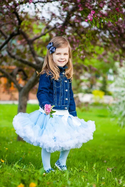 Modieuze lief meisje in een lentetuin — Stockfoto