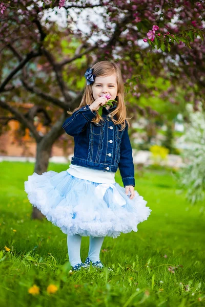 Fashionabla söt flicka i vårträdgård — Stockfoto