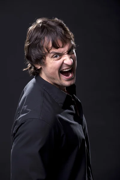 Muscular male in a black shirt shouting — Stock Photo, Image