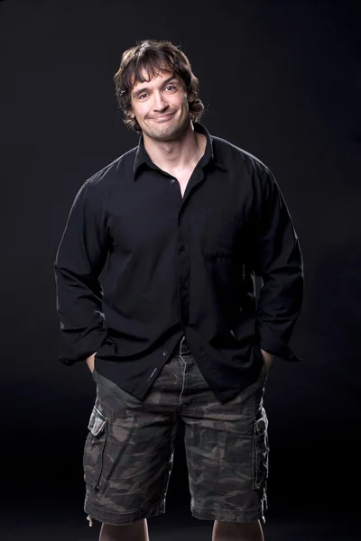 Musculoso macho en una camisa negra sonriendo — Foto de Stock
