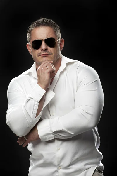 Muskulöser Mann im weißen Hemd posiert — Stockfoto