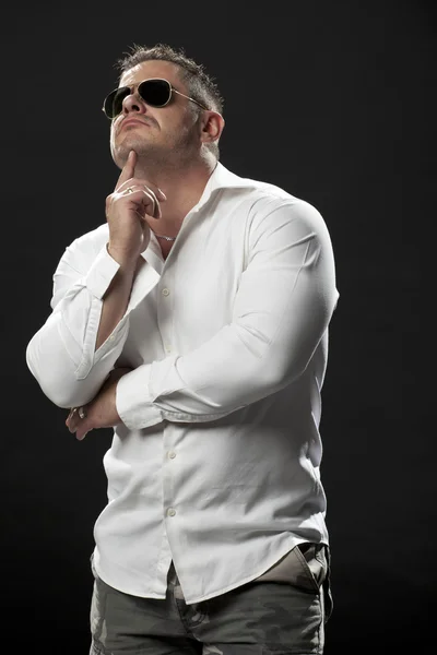 Muscular macho em uma camisa branca de pé e pensando — Fotografia de Stock