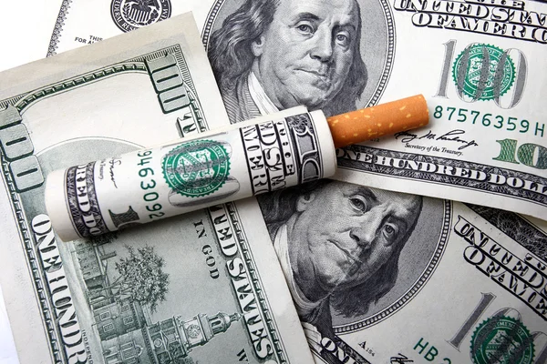 Honderd dollar bill en sigaret op een dollarbiljetten Stockfoto