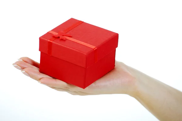 Mão feminina segurando uma caixa de presente vermelha — Fotografia de Stock