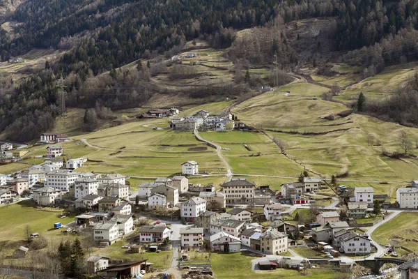 Pequeña ciudad en la ladera de la montaña Alp — Foto de Stock