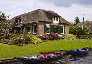 Thatched farmhouse near canal clipart