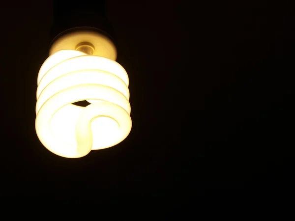 Spirala lampka na białym tle na czarnym tle — Zdjęcie stockowe