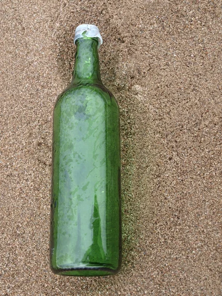 Zielone butelki na piasku — Zdjęcie stockowe