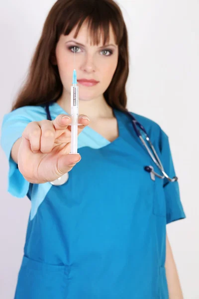 Kirurg i morgonrock med en stetoskop och spruta — Stockfoto