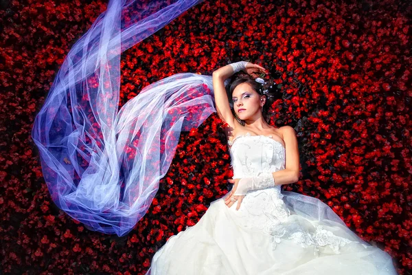 Bride is lying in flowers — Stock Photo, Image