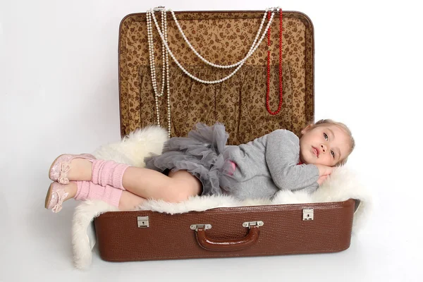Дівчина втомилася і лягла спати у валізі — стокове фото