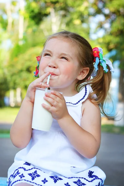 Girl drinking a milkshake through a straw — Stock Photo, Image