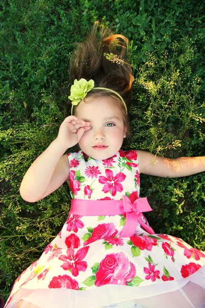 Chica en un vestido brillante acostado en el suelo y cierra los ojos —  Fotos de Stock
