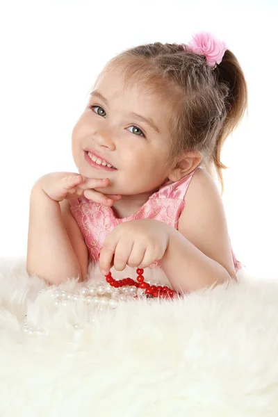 Девушка играет с бусами и улыбается — стоковое фото