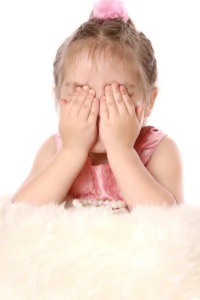 Menina brinca com pele e fecha os olhos com as mãos — Fotografia de Stock