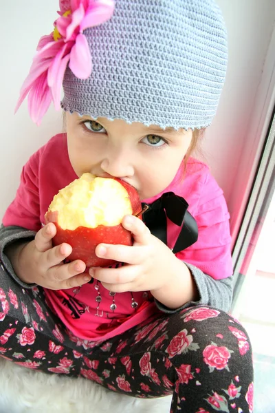 Girl eats a huge red apple — Stock Photo, Image